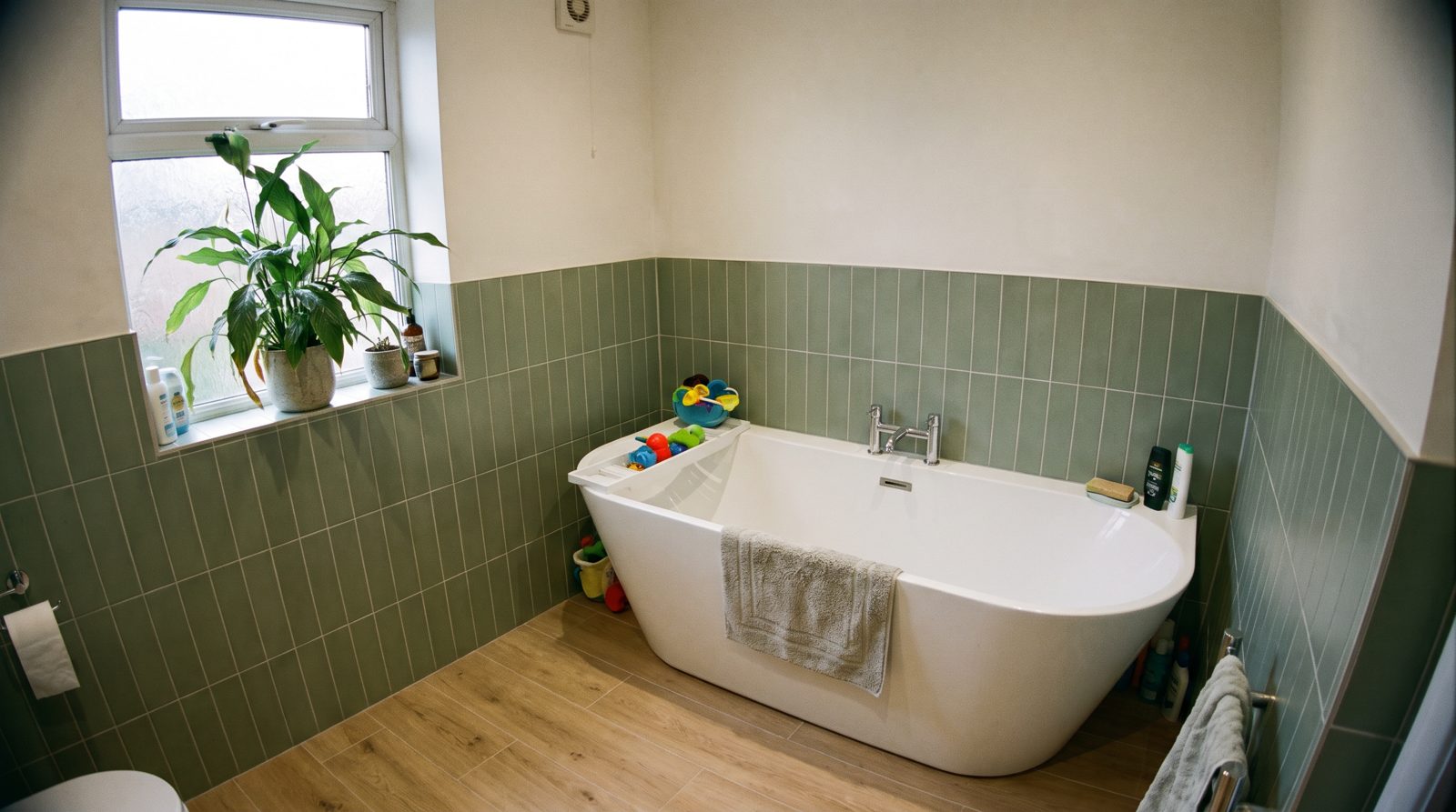 Family bathroom with stacked green wall tiles